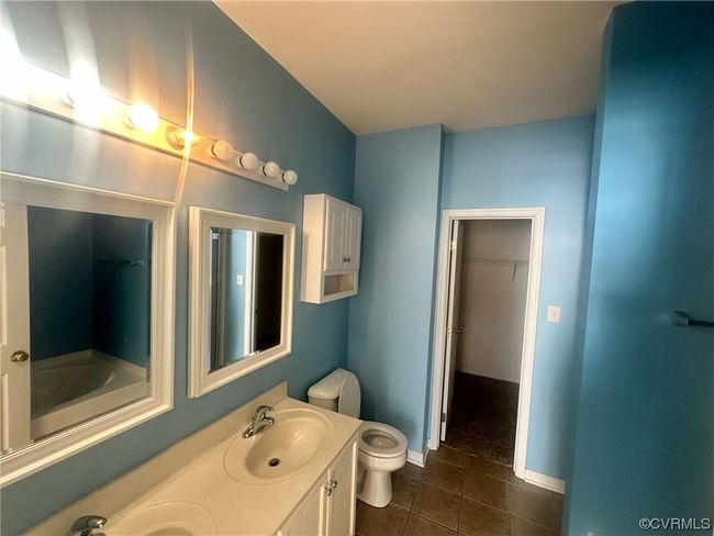 Bathroom featuring tile floors, double sink vanity, and toilet | Image 19