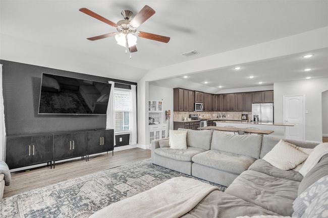 Living area featuring light wood finished floors, a ceiling fan, recessed lighting, and vaulted ceiling | Image 13