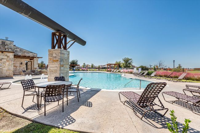 Community pool featuring a patio area, fence, and an outdoor stone fireplace | Image 36