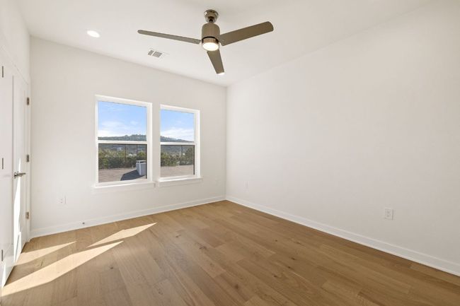 Empty room featuring recessed lighting, wood finished floors, a ceiling fan, visible vents, and baseboards | Image 25