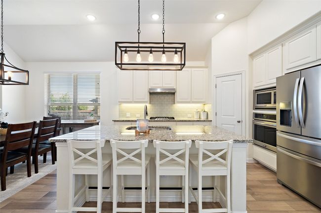 Bright and inviting kitchen with crisp white cabinetry, granite countertops, and a clean, timeless look. | Image 9