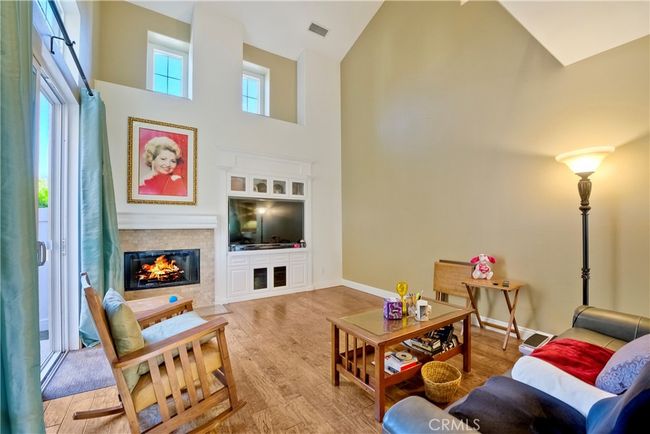 Inviting living room is graced with vaulted ceilings and high placed windows for a sunlit atmosphere | Image 17