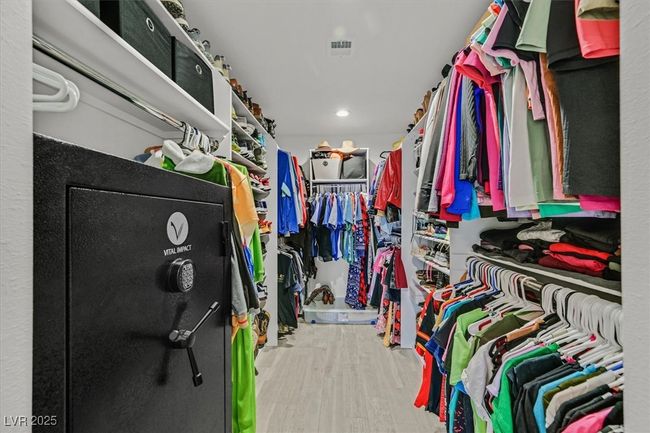 Walk in closet featuring visible vents and wood finished floors | Image 19