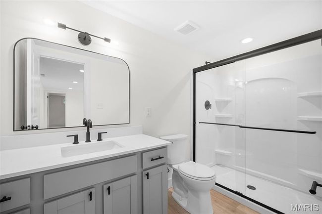 Bathroom featuring vanity, wood finished floors, a stall shower, and recessed lighting | Image 39