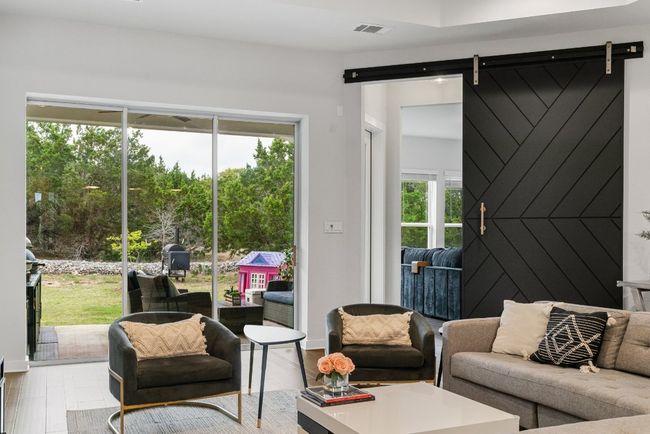 Living room with a barn door and wood finished floors | Image 18