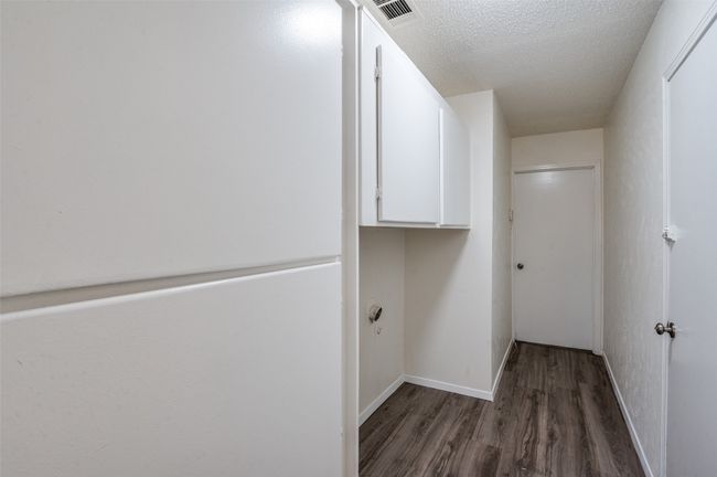 Laundry area with wood finished floors and a textured ceiling | Image 19