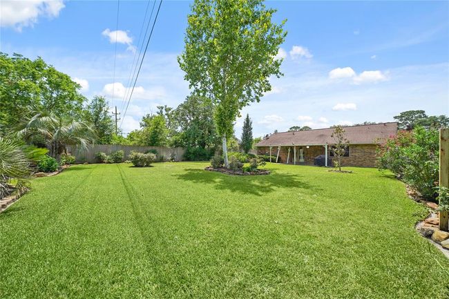 Expansive backyard with well-maintained lawn, mature trees, and landscaped borders, offering ample space for outdoor activities with no back neighbors! | Image 33
