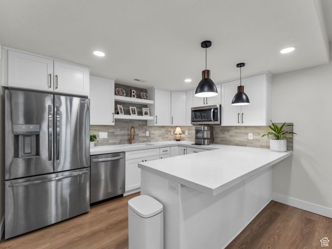 Kitchen with stainless steel appliances, a sink, open shelves, a peninsula, and tasteful backsplash | Image 35