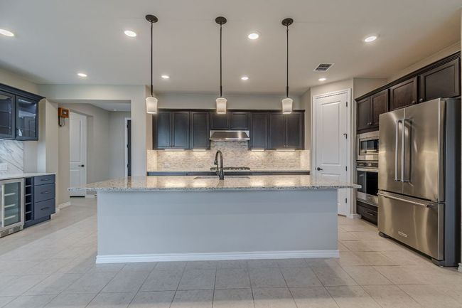 Kitchen featuring tasteful backsplash, stainless steel appliances, light tile patterned floors, and recessed lighting | Image 21