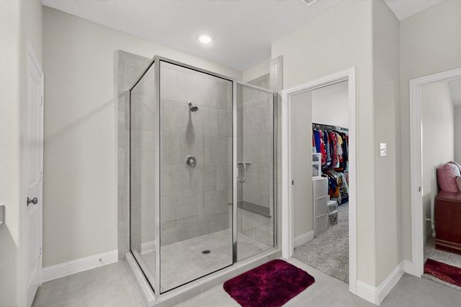 Full bath featuring a shower stall, a spacious closet, and tile patterned flooring | Image 21