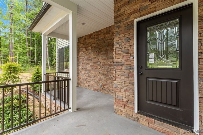 Doorway to property featuring a porch and stone siding | Image 8