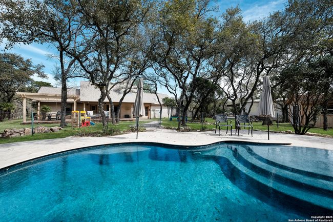 Fenced in, heated pool, with water features | Image 29