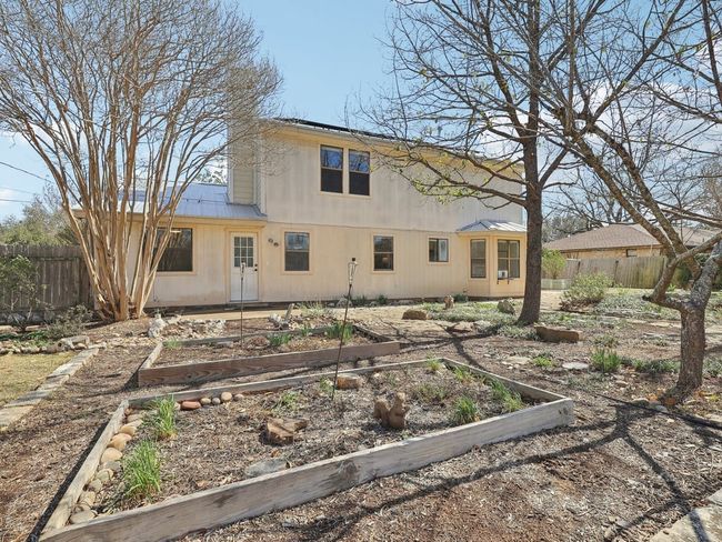 Rear view of property with metal roof, fence, and a vegetable garden | Image 31