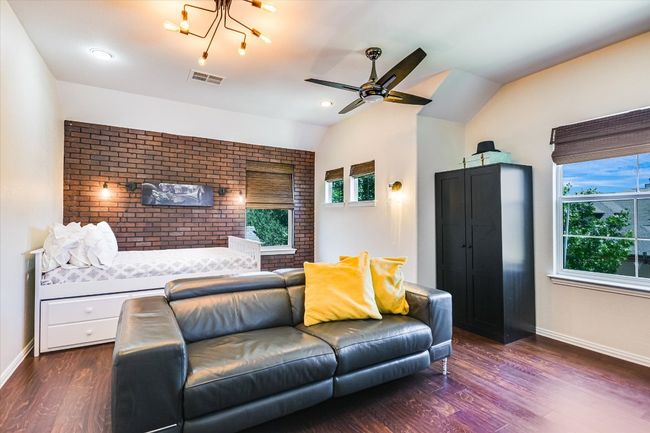 This large bedroom acts as a game room or guest bedroom with additional desk space | Image 16