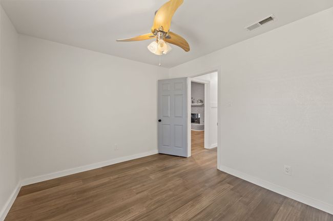 Unfurnished room featuring wood finished floors, baseboards, ceiling fan, and visible vents | Image 20