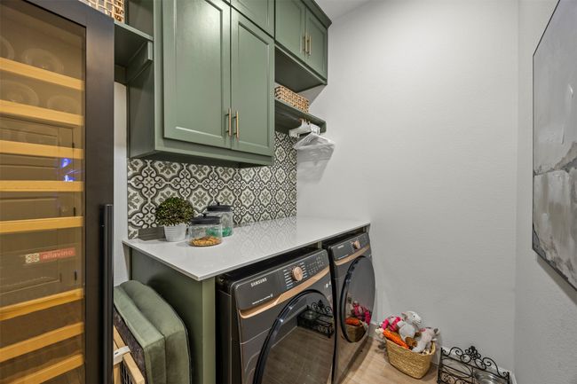 Laundry area with cabinet space, wine cooler, and washing machine and clothes dryer | Image 32