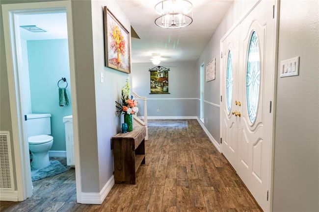 View from the living room toward the guest bath, french doors and the dining room beyond. | Image 9