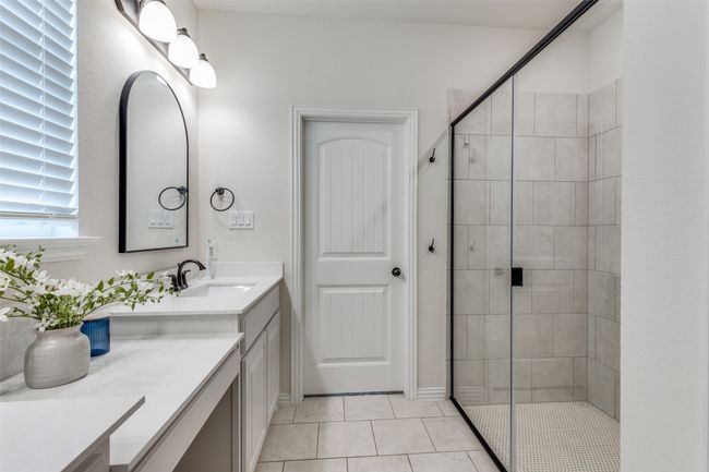 Bathroom with vanity, a shower stall, and tile patterned flooring | Image 18