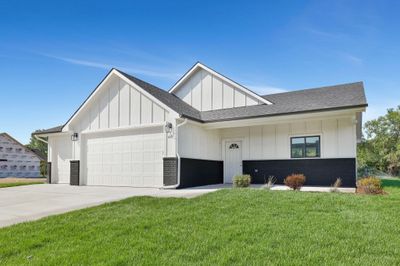 View of front of home featuring a front yard and a garage | Image 1