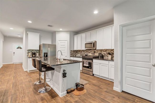 Another view of kitchen. To the right is primary bedroom door. Ahead is front door. Notice the wide entryway. | Image 18