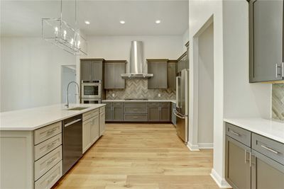 The kitchen has a sprawling center island with undermount stainless steel sink, push button garbage disposal, and Moen faucets. | Image 3