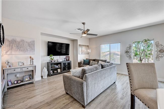 Living room with light wood-style floors and ceiling fan | Image 14