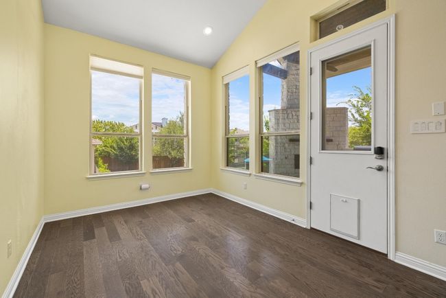 Unfurnished room featuring dark wood-type flooring, lofted ceiling, and recessed lighting | Image 10
