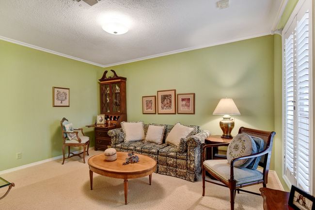 Carpeted living area with ornamental molding, baseboards, and a textured ceiling | Image 30