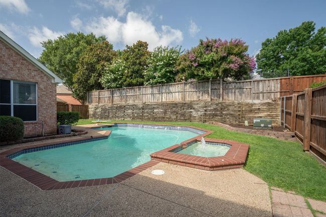 View of pool with a fenced backyard and a pool with connected hot tub | Image 36
