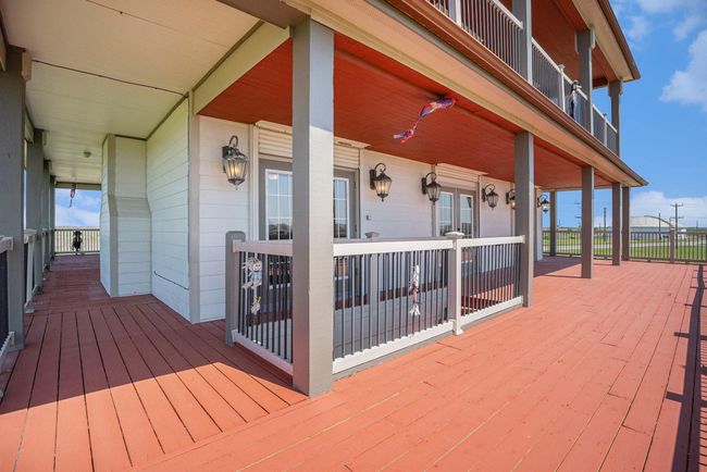 Step out onto the expansive wrap-around deck, an ideal space for outdoor enjoyment. For added peace of mind and convenience, all windows are equipped with automatic hurricane roll-down shutters. | Image 31