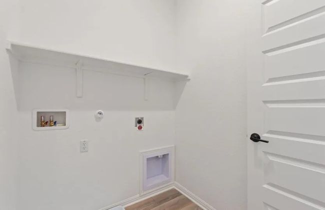 Washroom with washer hookup, gas dryer hookup, hookup for an electric dryer, wood finished floors, and baseboards | Image 9