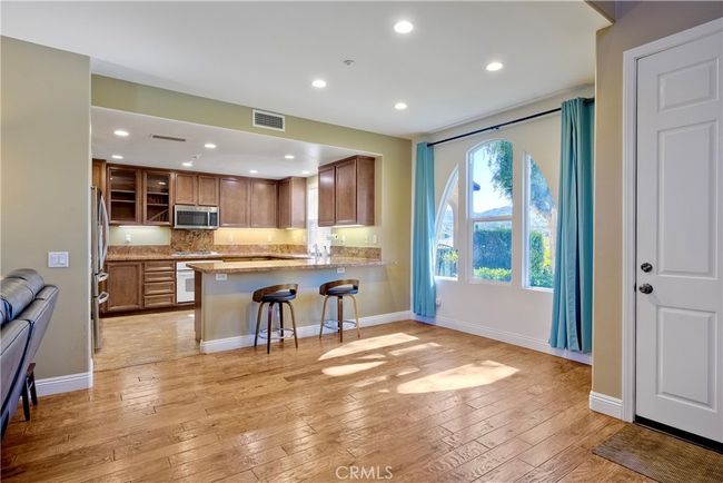 Photo is looking toward sunlit dining area with kitchen conveniently opening into dining area with living room to the left side of photo | Image 13