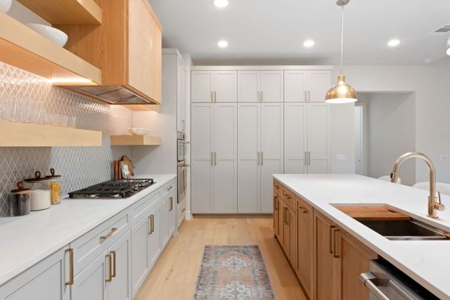 Kitchen with pendant lighting, light wood-style flooring, open shelves, a sink, and stainless steel appliances | Image 6
