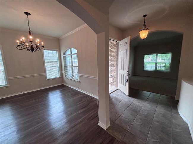 Foyer with arched walkways, a chandelier, ornamental molding, and dark wood-style flooring | Image 6