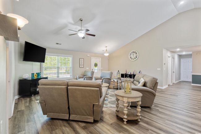 Living area featuring wood finished floors, ceiling fan, recessed lighting, and high vaulted ceiling | Image 11