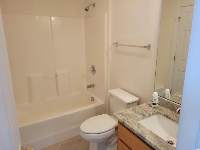 Bathroom with vanity, shower / tub combination, and tile patterned flooring | Image 6