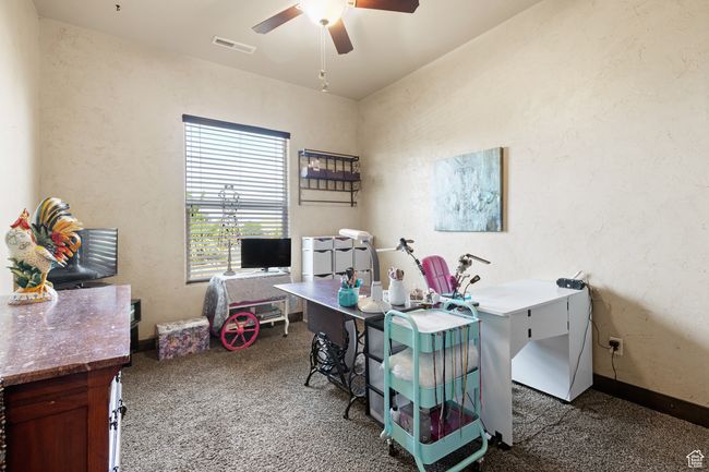 Home office with a ceiling fan, carpet flooring, and a textured wall | Image 13