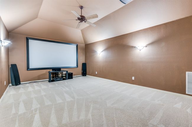 Carpeted cinema with vaulted ceiling and ceiling fan | Image 22