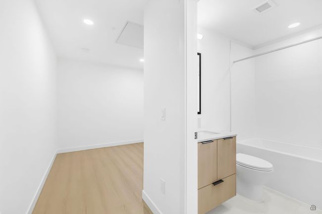 Bathroom with vanity, wood finished floors, visible vents, shower / bathing tub combination, and toilet | Image 18