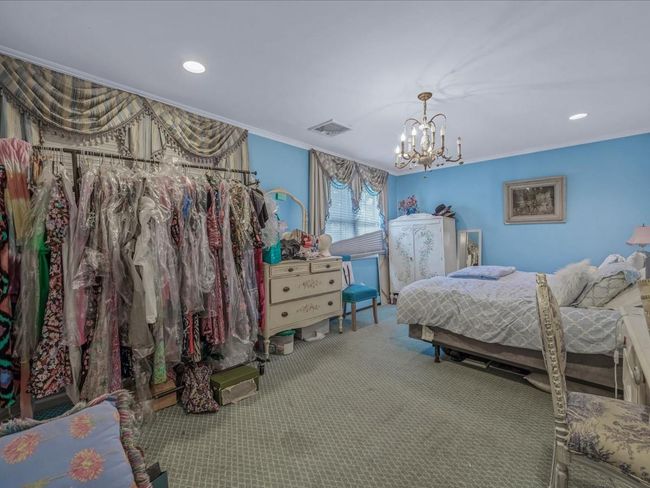 Bedroom featuring ornamental molding, a chandelier, carpet, and recessed lighting | Image 22