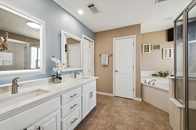 Elegant primary bathroom featuring double sinks, a separate shower, and a luxurious soaking tub. | Image 15