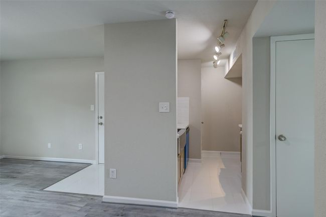 This photo shows a small kitchen area with track lighting and visible cabinetry. | Image 8