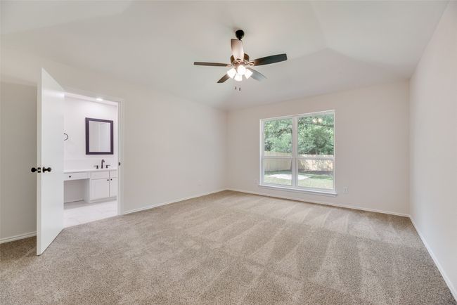 Empty room with a ceiling fan, light carpet, a sink, and baseboards | Image 11