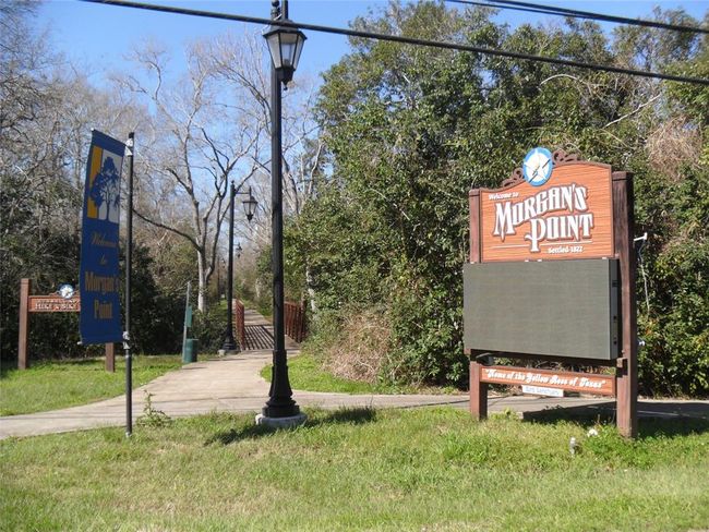 This photo shows the entrance to a scenic area called Morgan's Point, featuring a pathway, wooden signs, and nearby greenery. Ideal for nature enthusiasts seeking a peaceful community setting. | Image 5