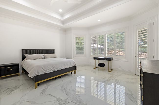 Bedroom with ornamental molding, a raised ceiling, light marble finish flooring, baseboards, and recessed lighting | Image 17