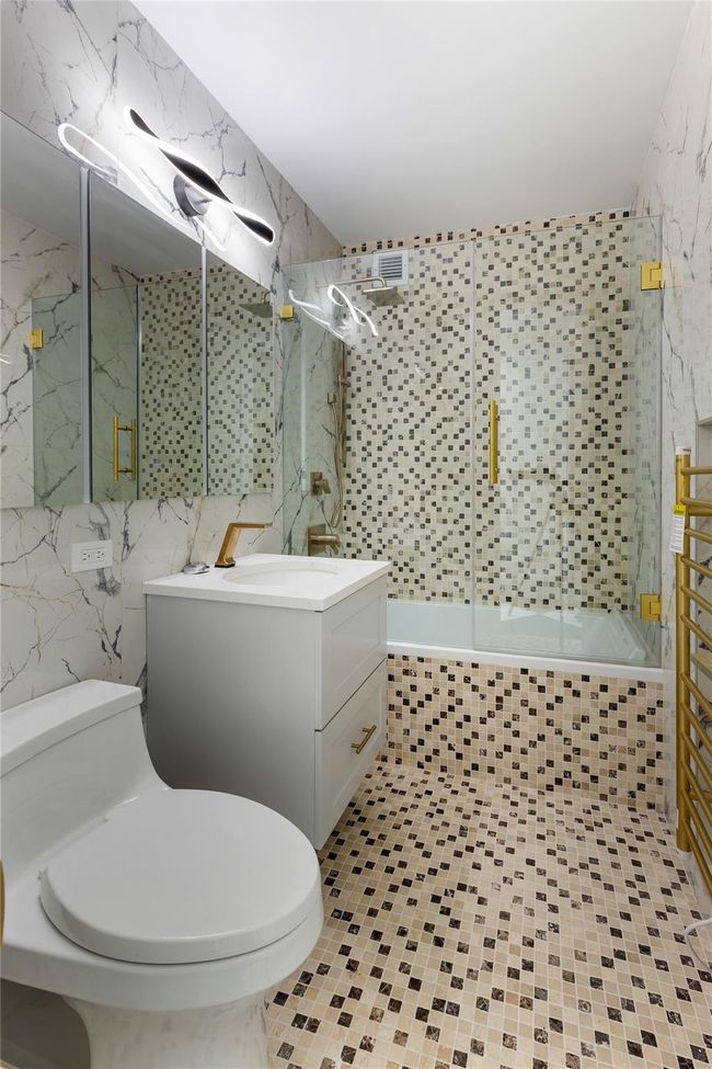 Full bath featuring tile walls, vanity, shower / bathtub combination, and tile patterned flooring | Image 15