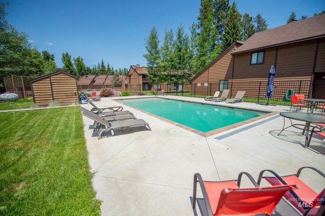 Community pool featuring a patio and a storage shed | Image 25