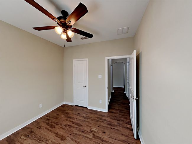 Unfurnished bedroom with dark wood finished floors and ceiling fan | Image 5