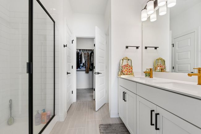 Bathroom featuring a stall shower, double vanity, and a spacious closet | Image 16