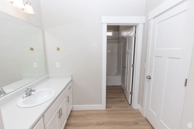 Bathroom featuring vanity, wood finished floors, baseboards, and a shower | Image 20